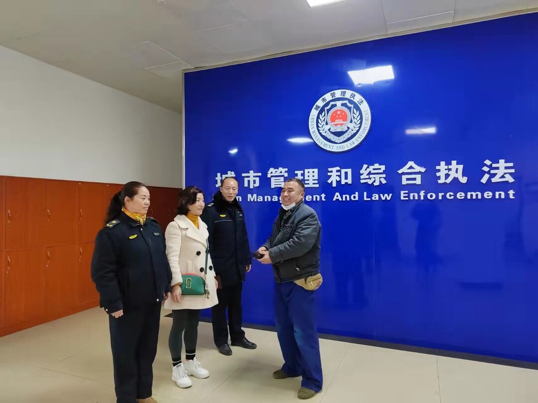 城管執(zhí)法人員撿拾錢包找失主  拾金不昧顯美德
